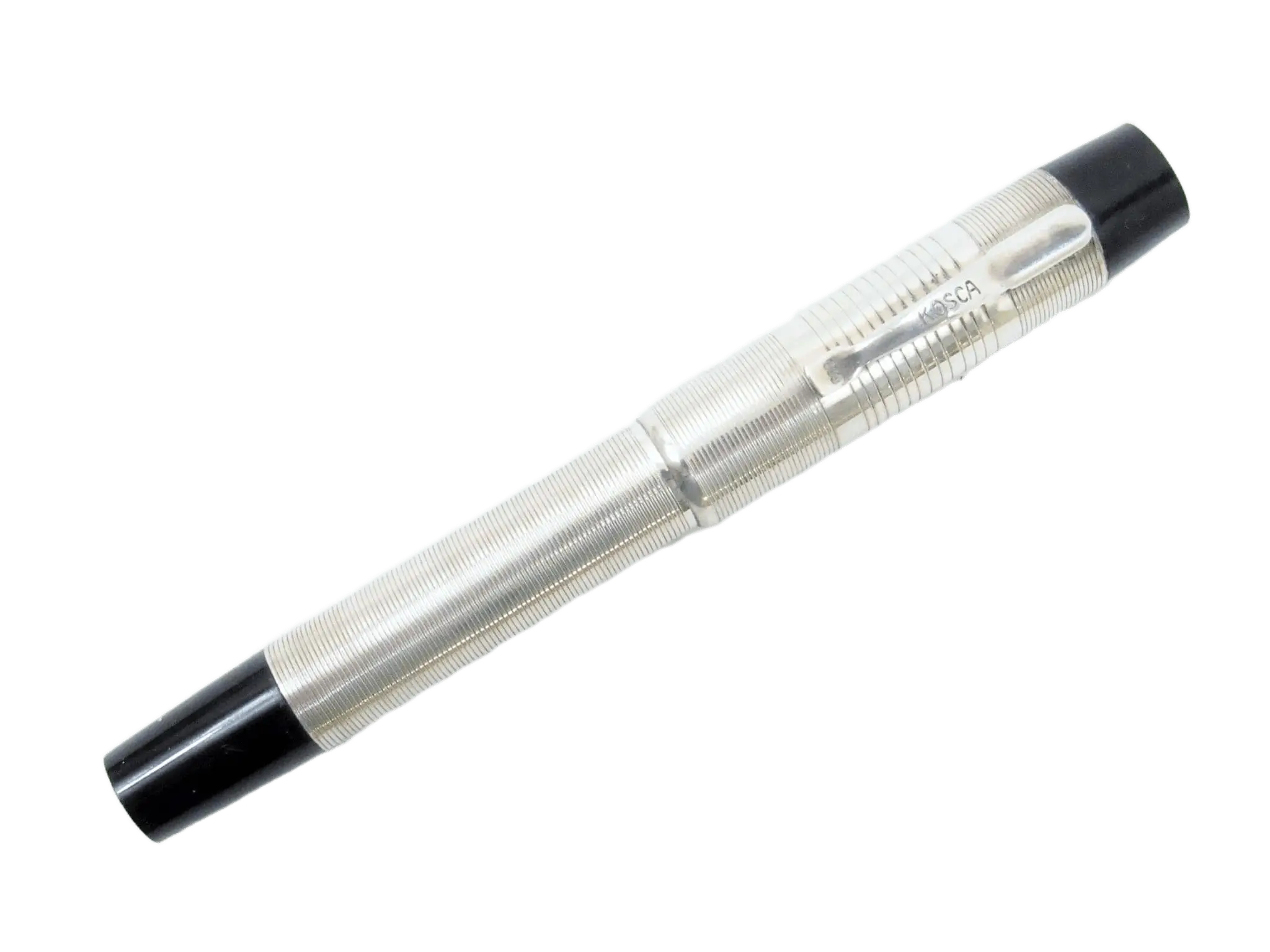 Detailaufnahme eines silberfarbenen Kosca Füllfederhalters mit schwarzer Kappe vor grünem Hintergrund.