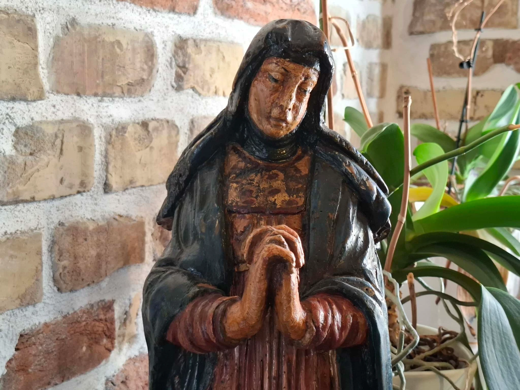 Holzstatue einer betenden, gekleideten Heiligenfigur