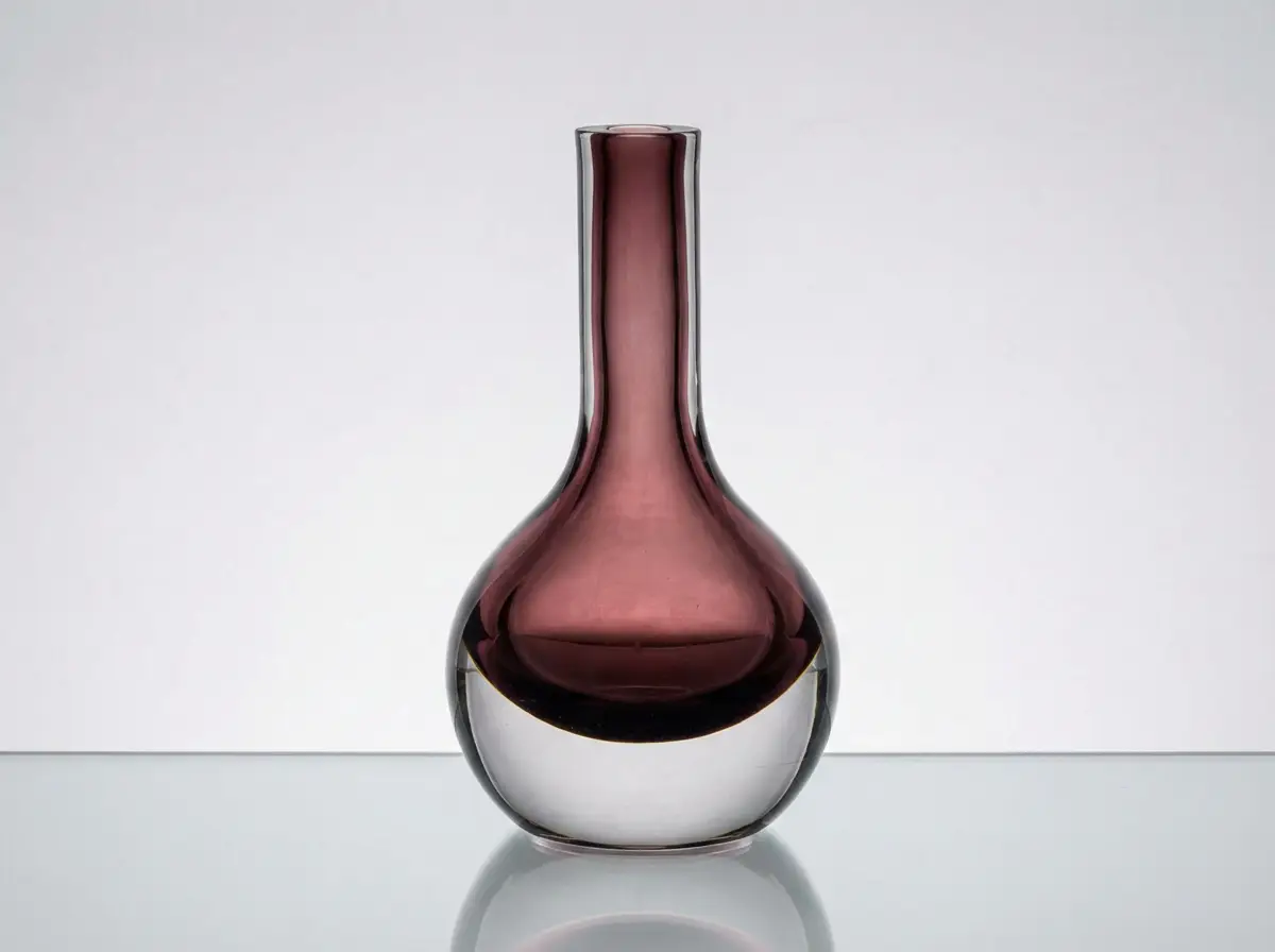 Bauchige Glasvase mit schmalem Hals in Aubergine-Lila, eingefasst in massives Klarglas am Boden, auf spiegelndem Untergrund