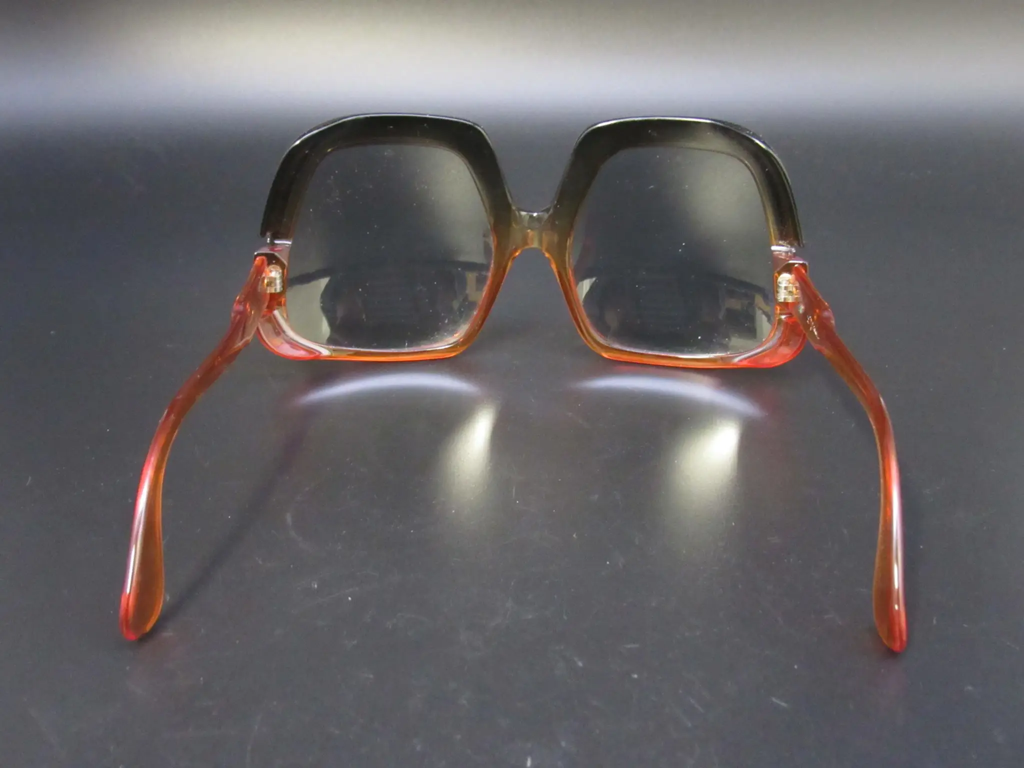 Rückansicht einer quadratischen Vintage-Brille mit zweifarbigem Rahmen in Schwarz und transparentem Orange