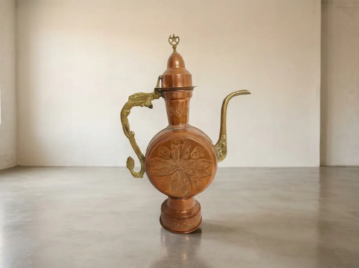 Antike orientalische Kupferkanne mit Messingverzierungen, kunstvollem Griff und Halbmond-Symbol auf dem Deckel vor hellem Hintergrund
