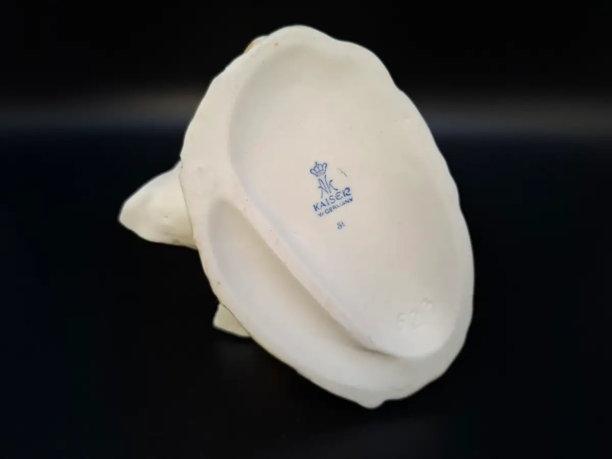 Unterseite einer weißen Porzellanfigur mit der blauen Bodenmarke von AK Kaiser, beschriftet mit W. Germany und einer Krone.